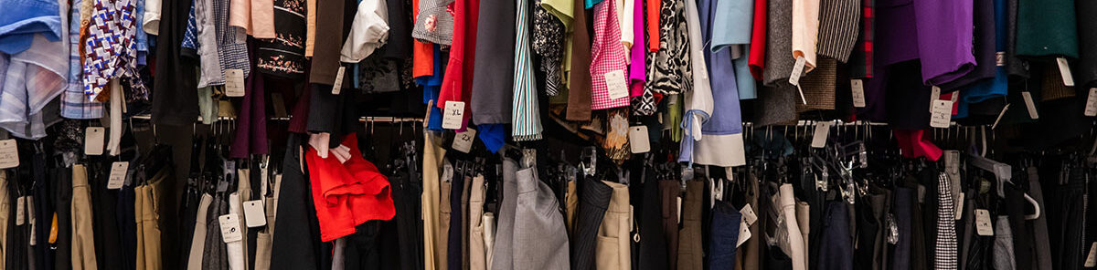 A picture of women's and men's business clothing with sizing tags, representing Smokey's Closet