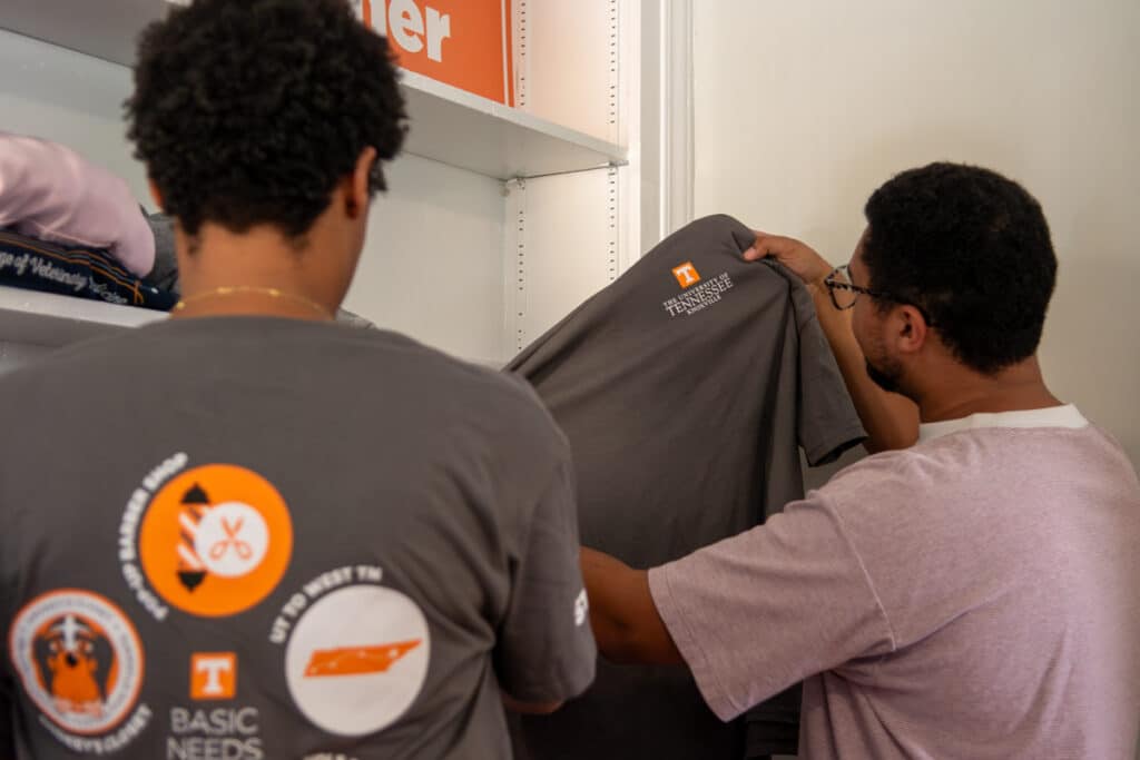 Two students look at shirts at the Free Store.
