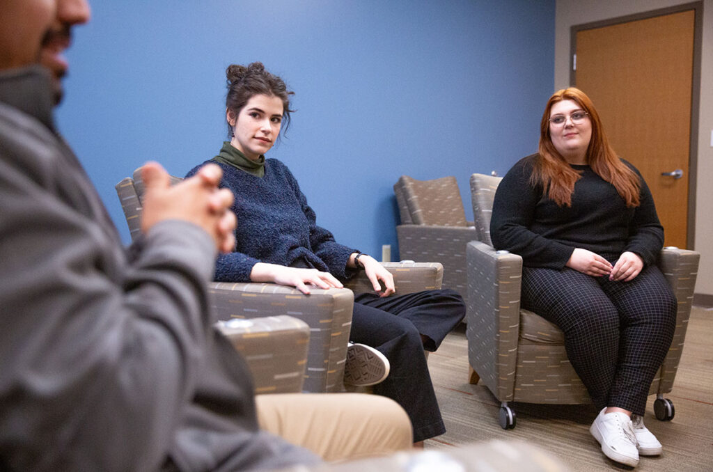 Three people in a group therapy session.