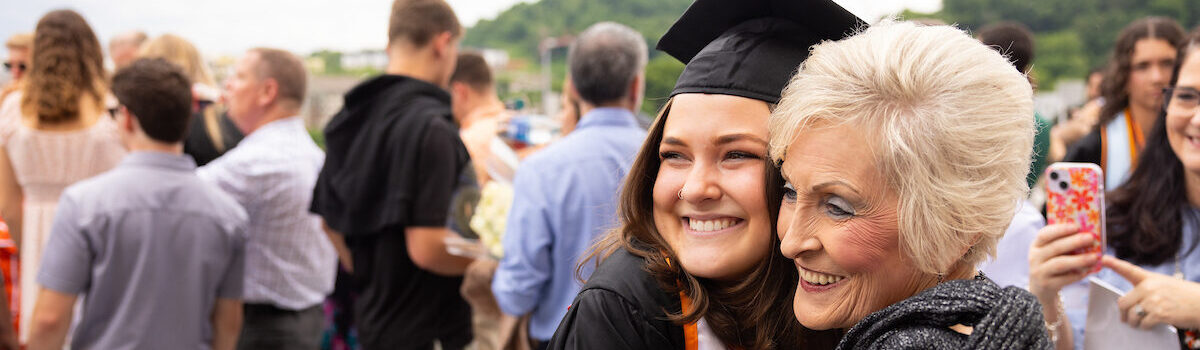 A graduate hugs family after the Haslam College of Business commencement ceremony inside Thompson-Boling Arena at Food City Center on May 18, 2024.