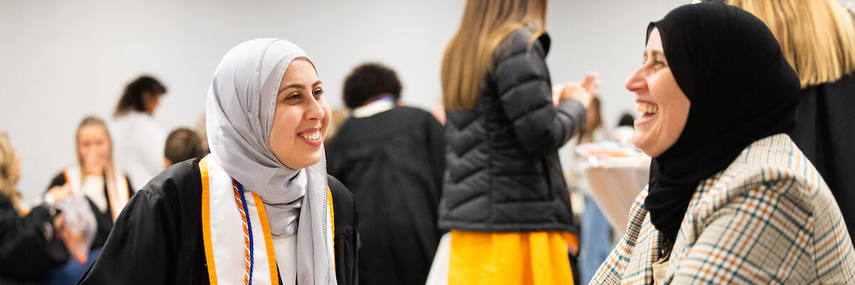 Student laughing with parent during Torch Night in the Student Union Ballroom on December 12, 2024.