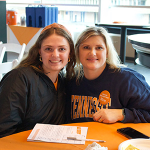 A mother and daughter smiling inside of the Tennessee Athletic Facility during Spring Family Reunion.