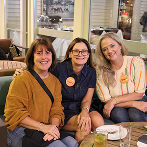 Three Tennessee Volunteer mothers gathered outside of a firepit for a Vol Family Social.