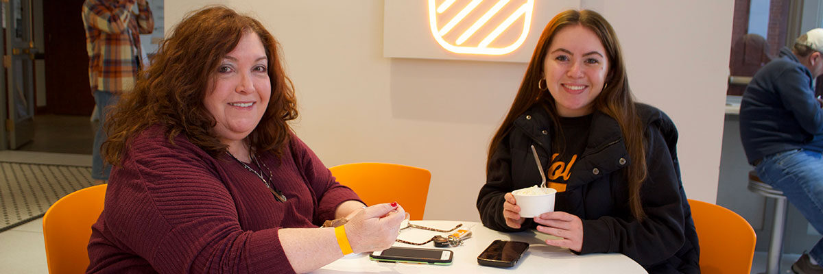 A mother and daughter are pictured at a table within the UT Creamery during Spring Family Reunion.