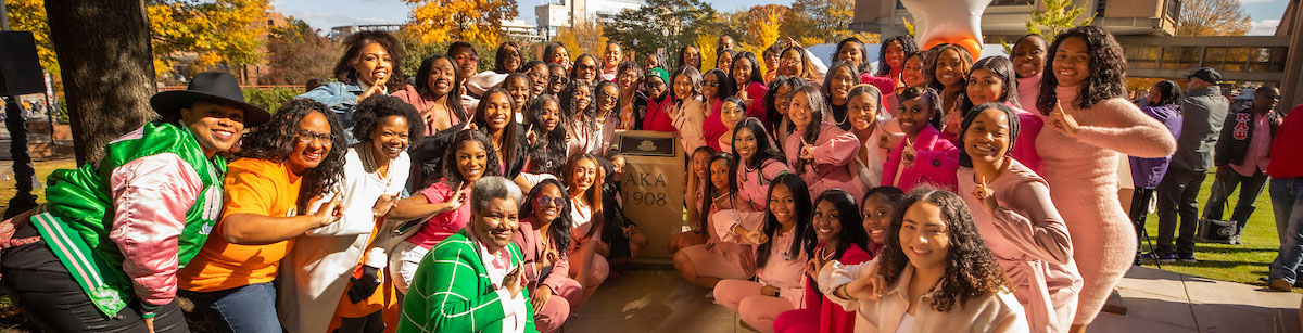 Current and former members of Alpha Kappa Alpha standing next to the new AKA structure on PED Walkway.