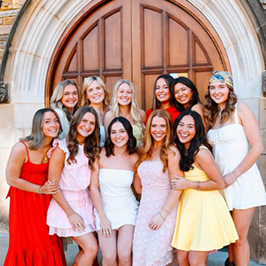 Several executive members of Chi Omega smiling for a group photo outside of a church in downtown Knoxville.