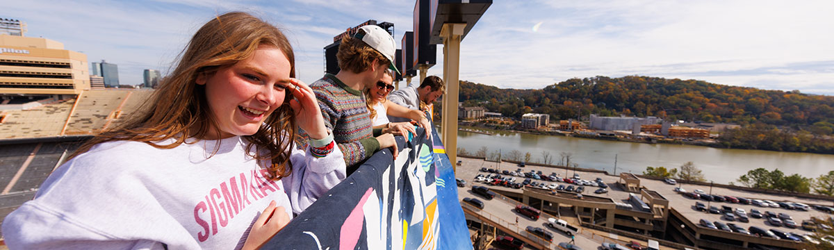 Horizontal image of the Homecoming Banner drop on the top of Neyland Stadium. One female, who is part of Sigma Kappa, is pictured in the forefront of the image.