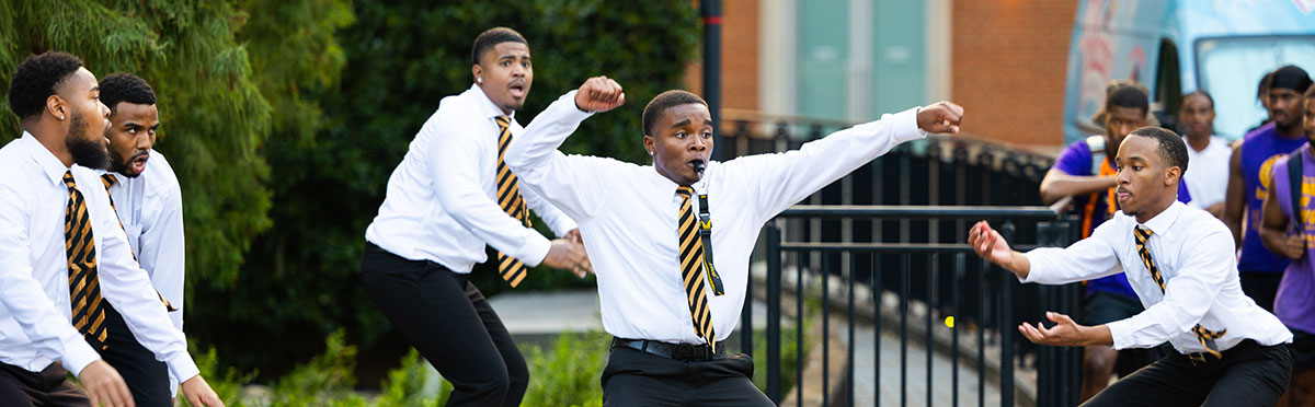Five members of a fraternity in the common area of the Student Union. This photo was taken at the Meet The Greeks event.