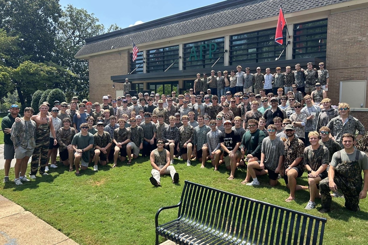 Dozens of members of the fraternity, Alpha Gamma Rho, in front of their fraternity house, which is located in Fraternity Park.