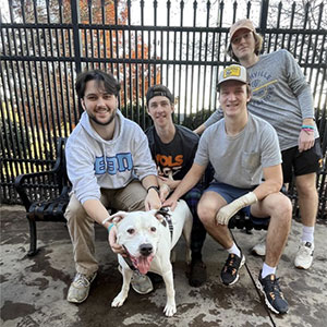 Four members of Beta Theta Pi at Young Williams Animal Center during a philanthropy event.