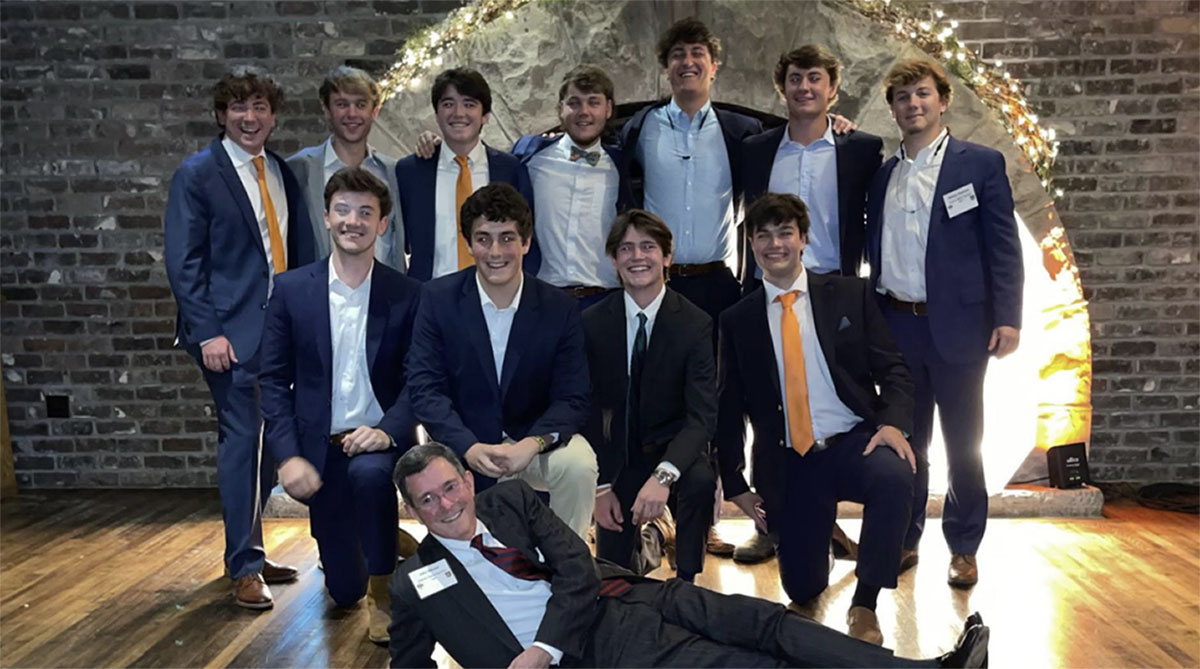 Eleven members of Sigma Alpha Epsilon smiling with their chapter advisor. They are all dressed in suits for a formal fraternity event at The Foundry in Knoxville, Tennessee.