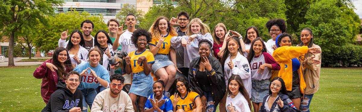 Students pose for a group photo with the Smokey statue at Circle Park during a lifestyle photo shoot for the Office of Sorority and Fraternity Life.