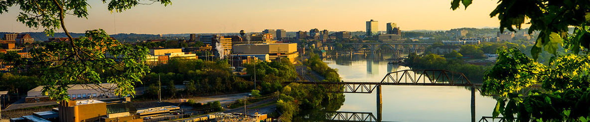 A scenic of the University of Tennessee campus over the river during sunset.