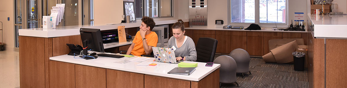 Two students sitting at the front desk in Stokely Hall