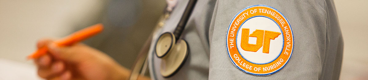 A close up of a University of Tennessee Knoxville college of Nursing badge on the left shoulder of a student who is wearing a stethoscope around their neck