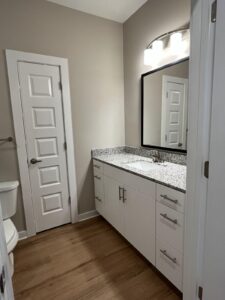 The bathroom with a linen closet, toilet and walk in built in sink and cabinets