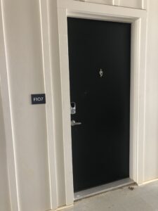 The black exterior door leading into an apartment