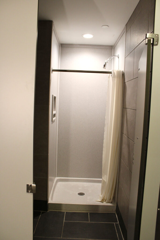 The shower in Magnolia Hall with the curtain pulled back showing the inside of the shower