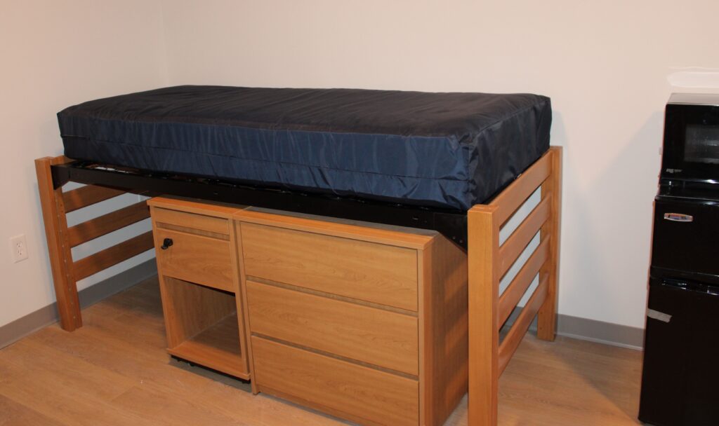 A single bed with a dresser positioned underneith it