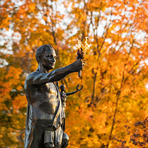 Torchbearer with fall leaves behind it.