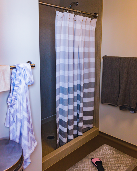 The shower setup with a striped shower curtain
