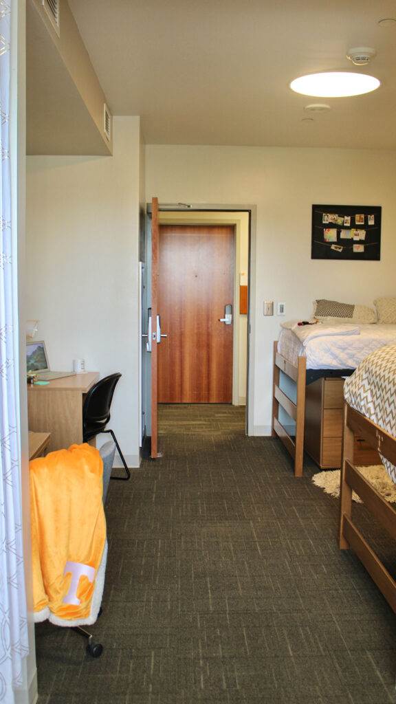 A view from a decorated dorm room that looks out into the hallway