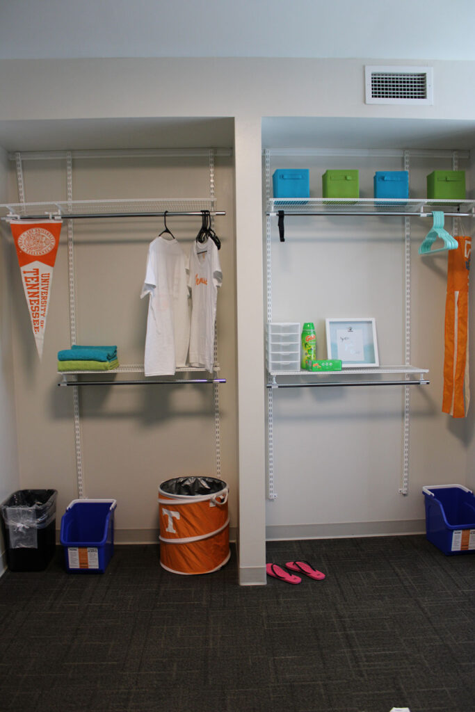 A decorated closet with a top shelf and a half middle shelf
