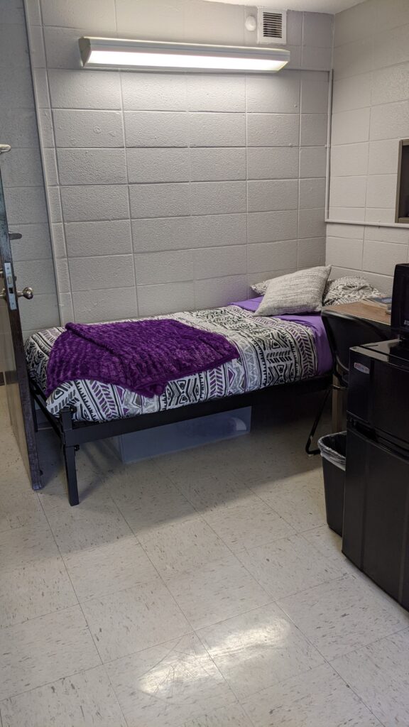 Decorated side of a dorm room in Reese Hall showing a bed.