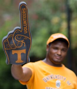 A male fan shows his TN pride decked out in UT tshirt and Power T foam finger.