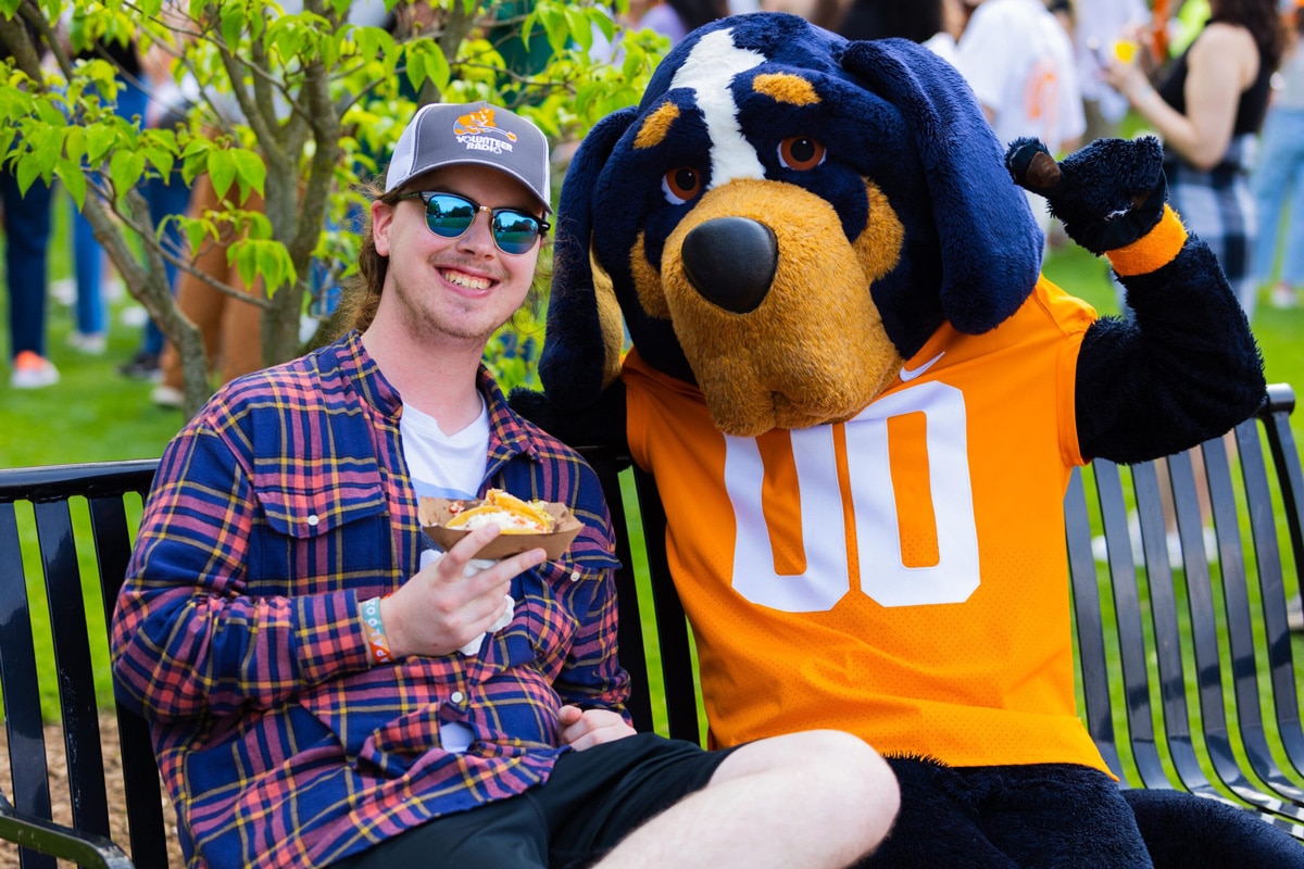 student sitting on a bench with Smokey