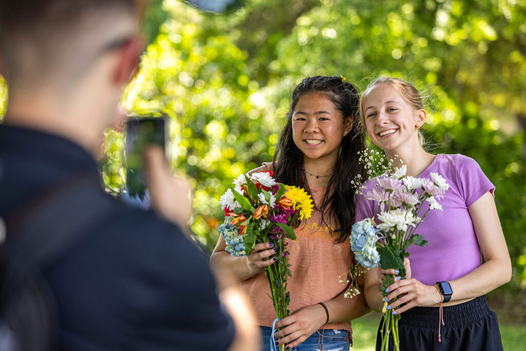 Students pose with flowers during Garden Party event.