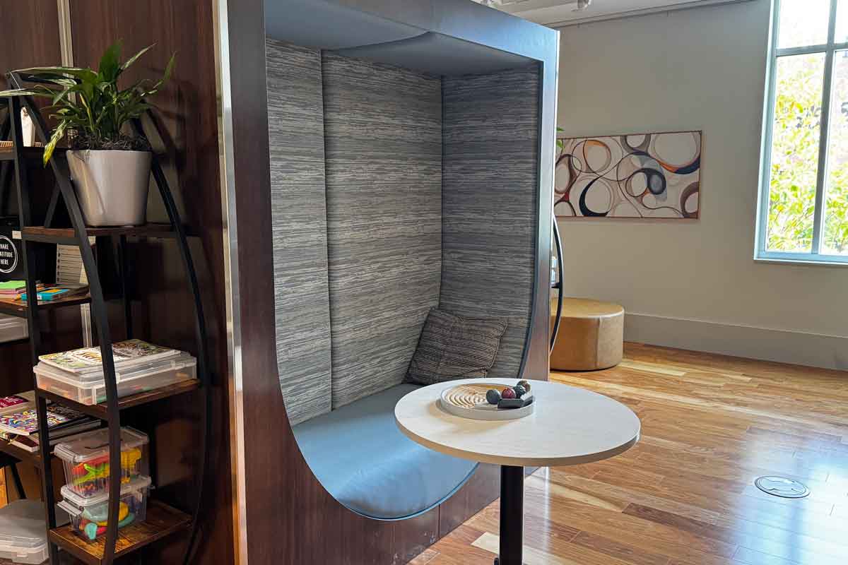 a bench and table behind a bookshelf