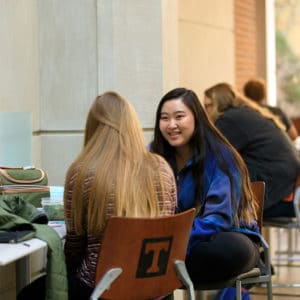 Students chat in an area in the lobby of the Haslam Business Building