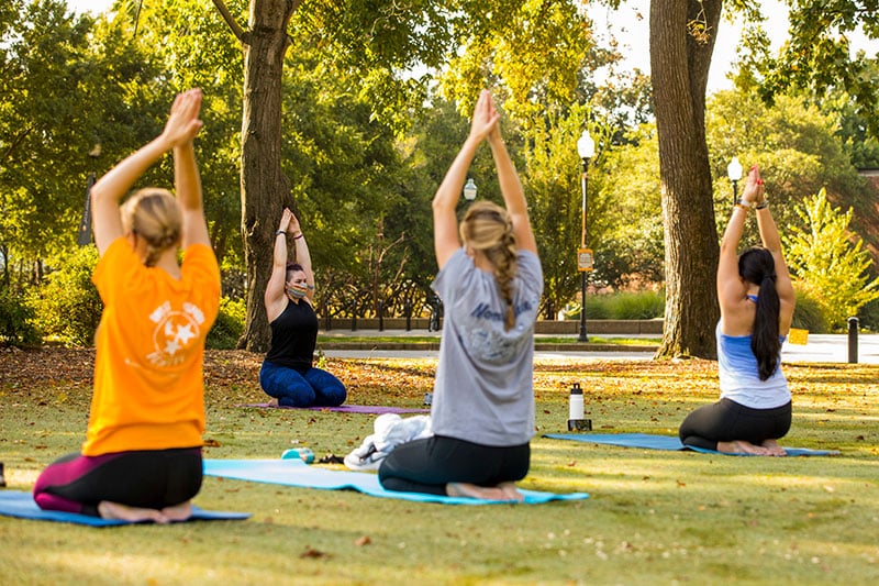 Students practice yoga in Circle Park