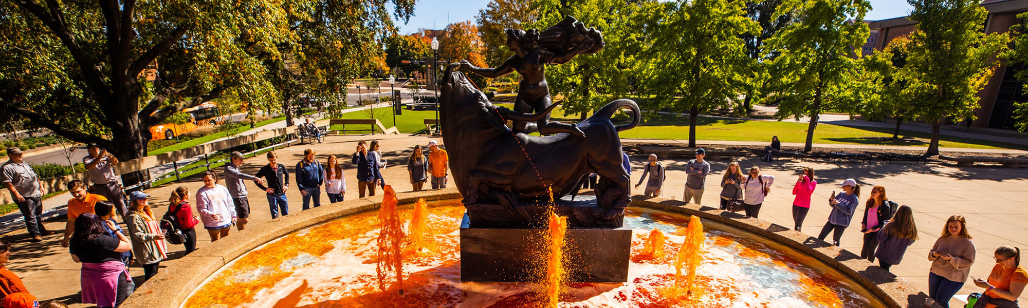 Students gather around the fountain filled with orange water