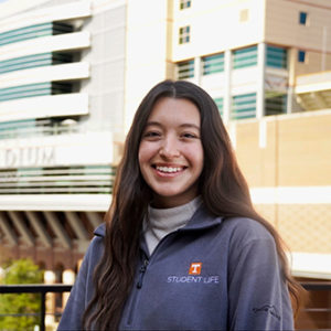 Photos of Cecilia Demoski in front of Neyland Stadium with a grey sweater