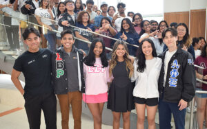 Presidents from MGC organizations pose for a group photo in the Student Union with a crowd of organization members behind them on stairs