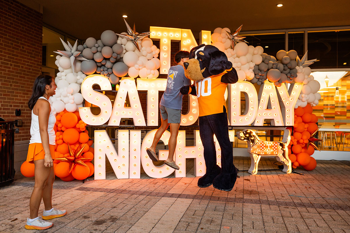 Smokey jumps to bump with a student at the Student Union during a Tennessee Saturday Night.