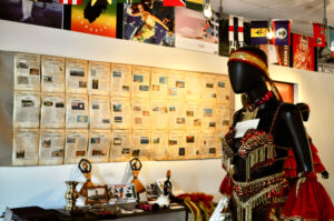 Carribean art exhibit items on wall and mannequin.