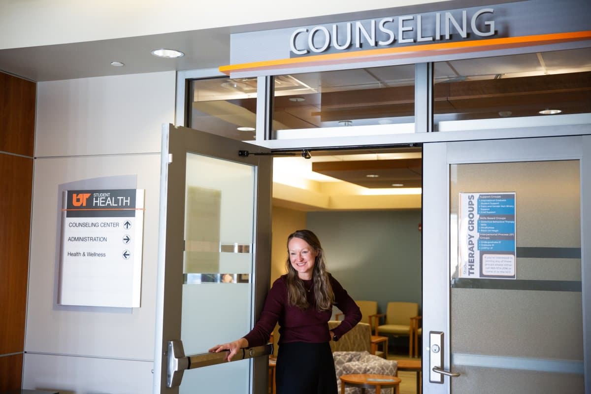 Employee holding the door open to the Student Counseling Center.