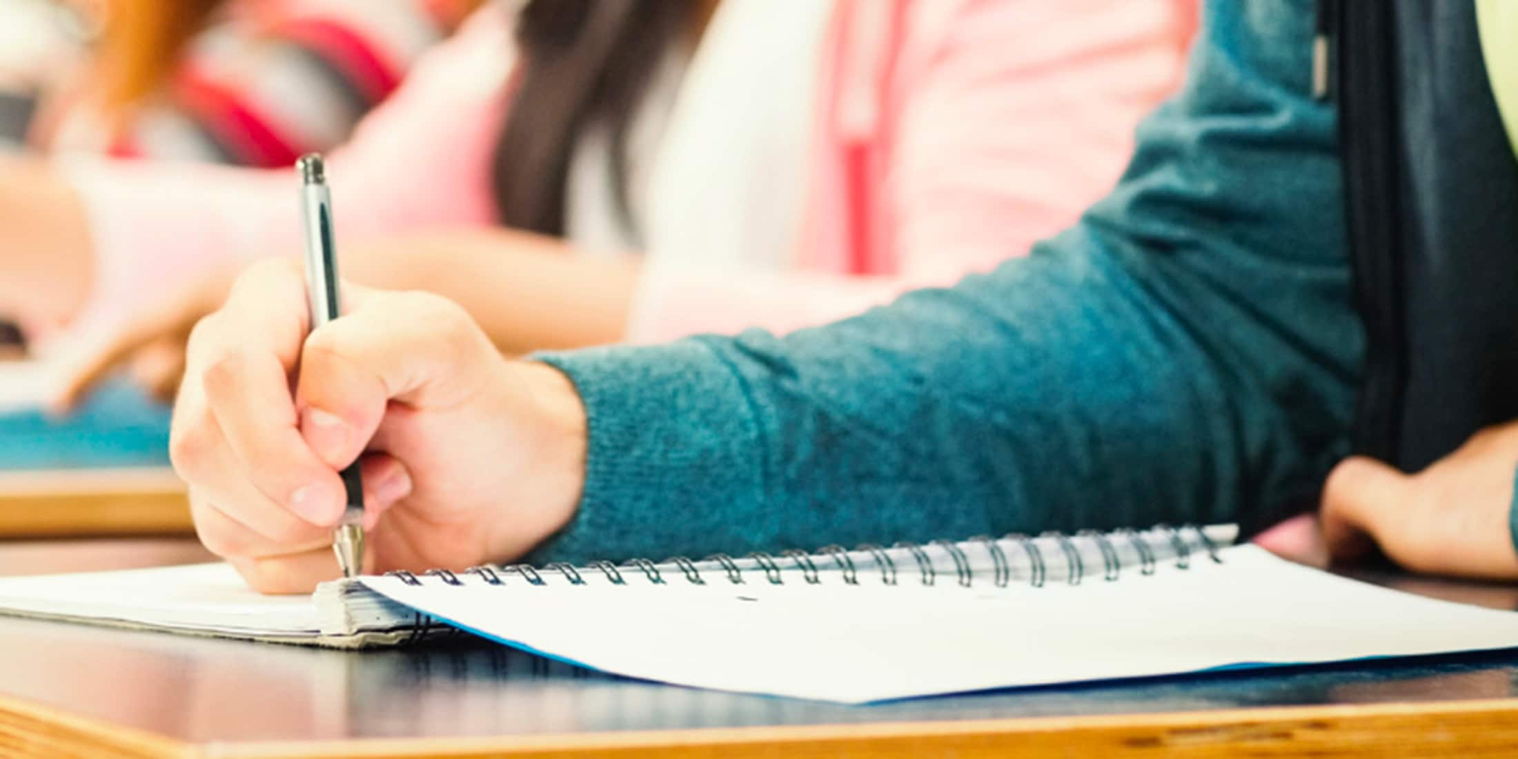 a person sits at a desk and takes notes