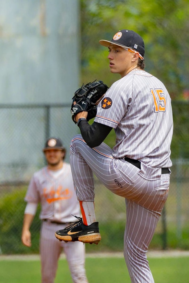 a person in a baseball uniform pitching a baseball